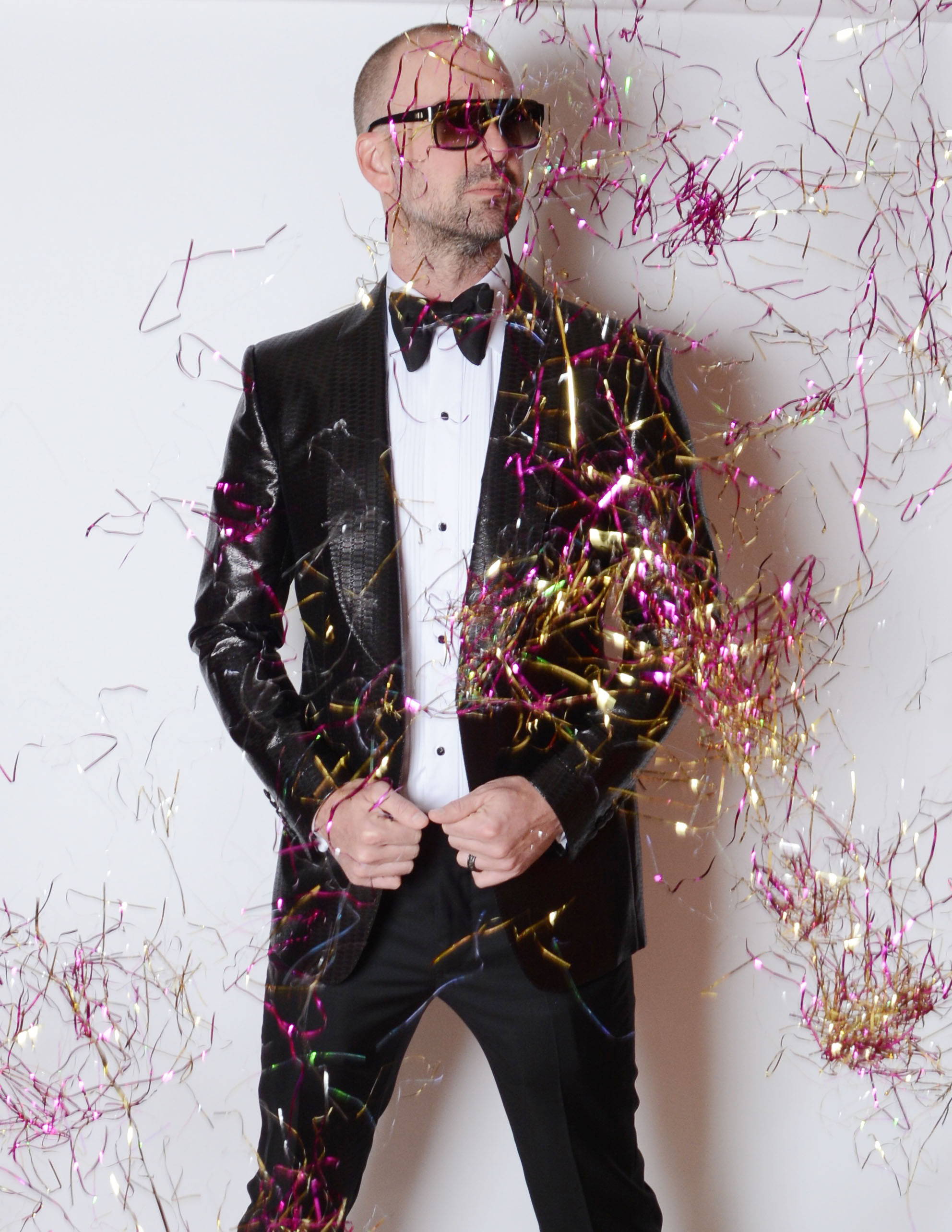 Dr. Barczak in a black tux and sunglasses with confetti dropping down on him