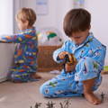 Two boys in pajamas playing with toys.