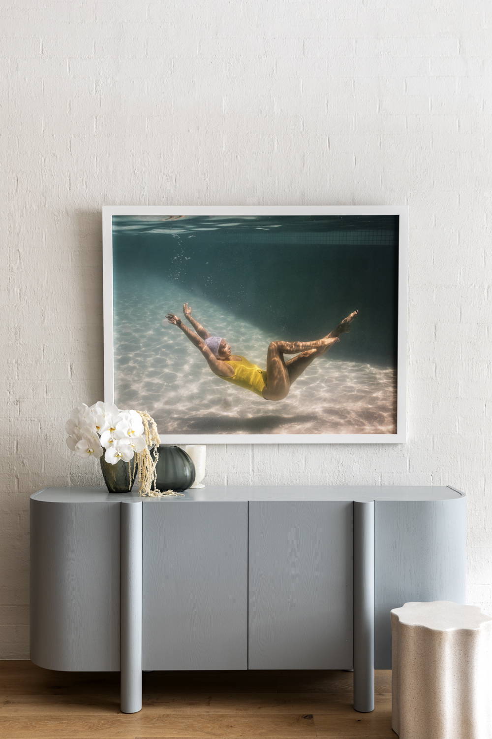 Halcyon Daze 1 by Francesca Owen - Underwater photography of a synchronised swimmer in yellow leotard and white cap posing underwater.