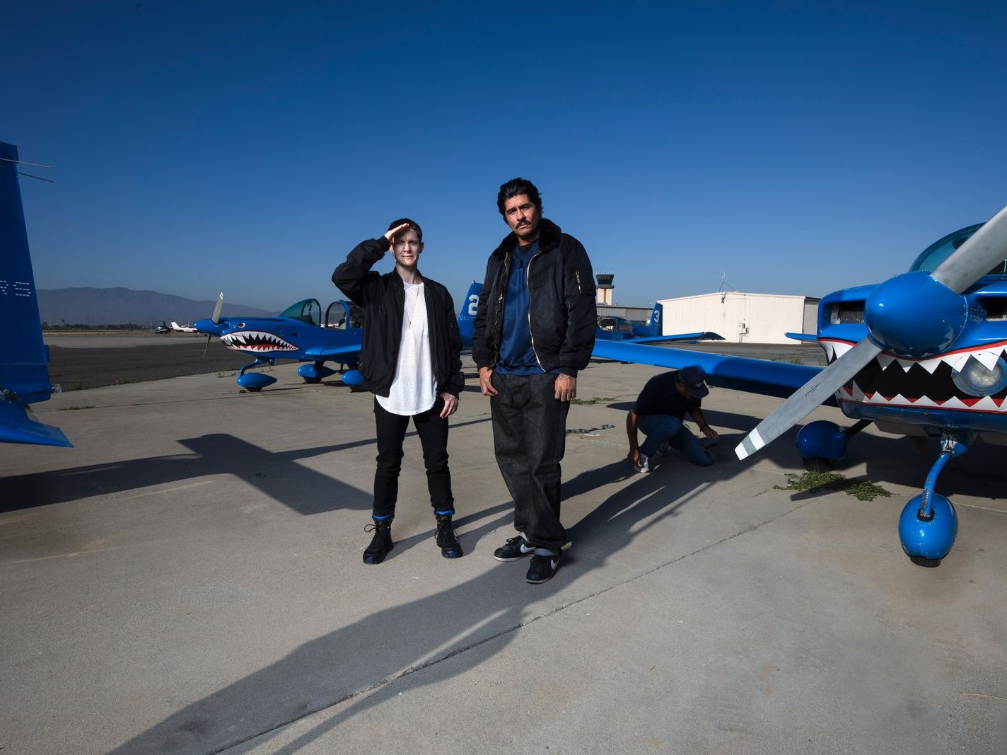 Rafa Esparza and Cassils stand in front of a plane