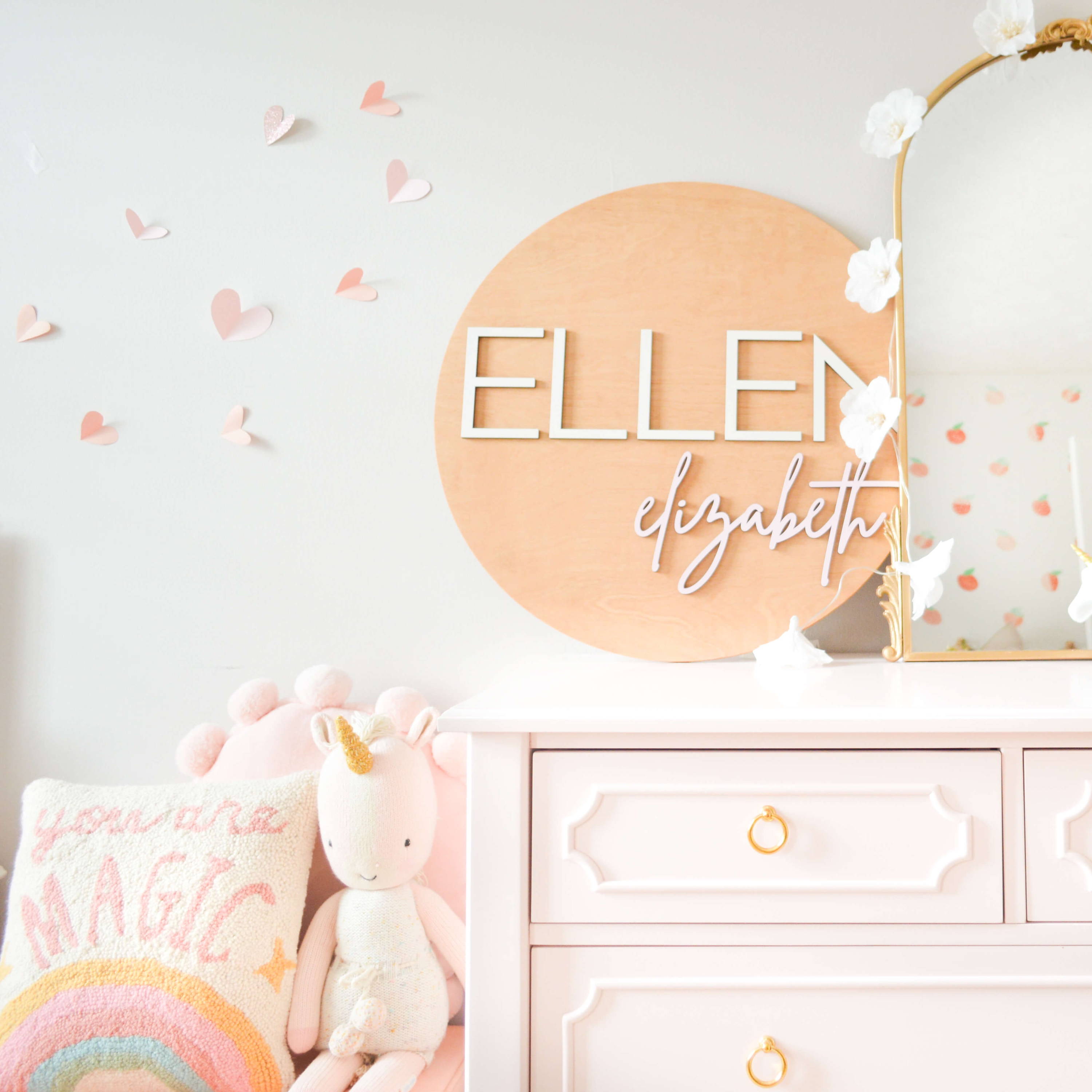 Round nursery name sign for little girls bedroom.  Circular wooden name sign for Ellen Elizabeth in sweet girls bedroom with soft blush pink and gold accents