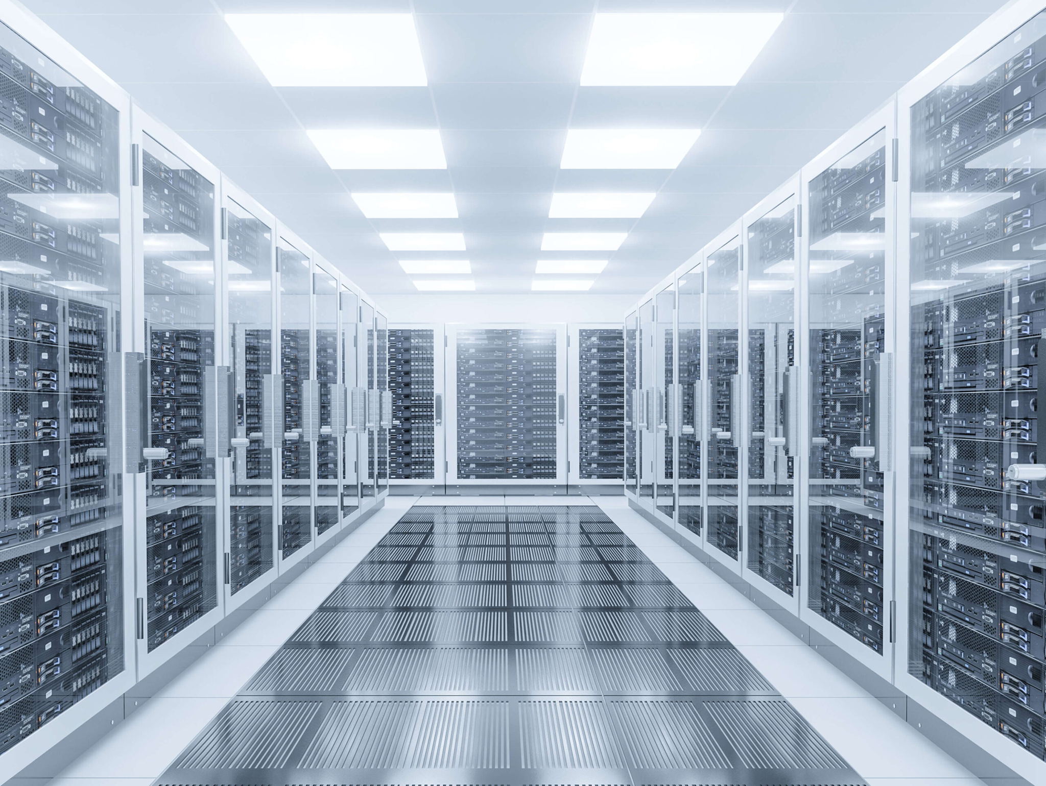 A modern data center with rows of server racks enclosed in glass cabinets on both sides. The floor is reflective with a metallic mesh design, and the ceiling displays bright, evenly spaced square lights, creating a sleek, high-tech atmosphere.