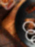 Spicy grilled chicken wings with onion rings on a black plate, garnished with chili flakes