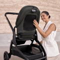 Lifestyle photo showing a parent using the Redsbaby ONIX pram outdoors.
