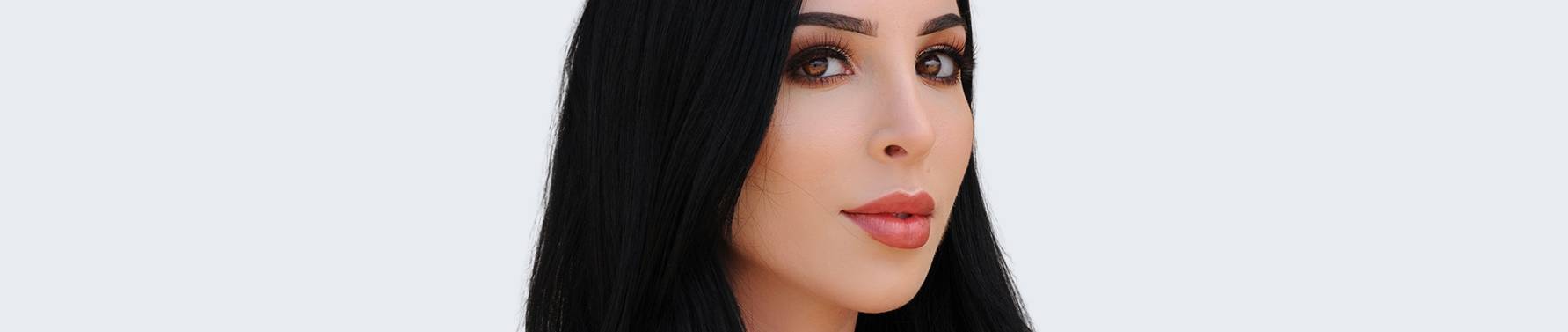 Headshot of beautiful woman with long dark hair and cute nose