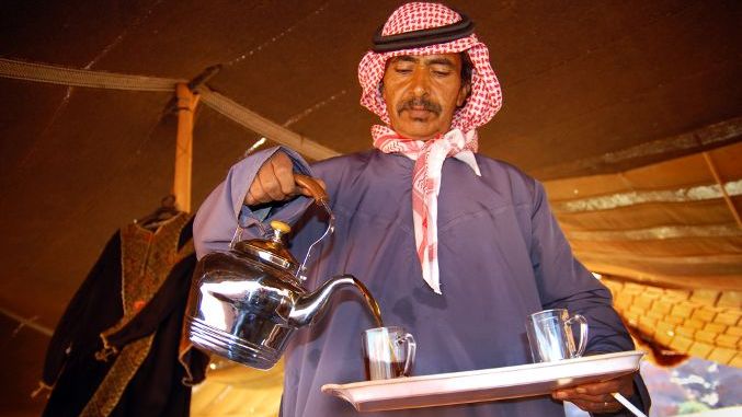 WADI RUM - NOV 10 2007Jordanian Arab Bedouin man pouring hot coffee from a jug into a cup in Wadi Rum, Jordan.The Bedouins are world famous for their culture and warm hospitality in the desert.