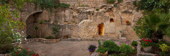 Panoramic image of Jesus' empty tomb. A light shines from inisde. 