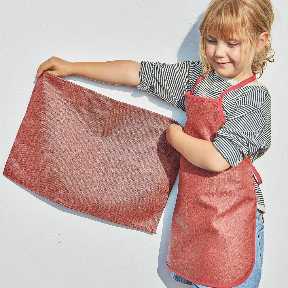 Un petit garçon utilise des couverts enfant pour dresser le couvert