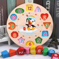 Colorful children's clock with a penguin illustration in the middle, colorful numbers, and a wooden base. 