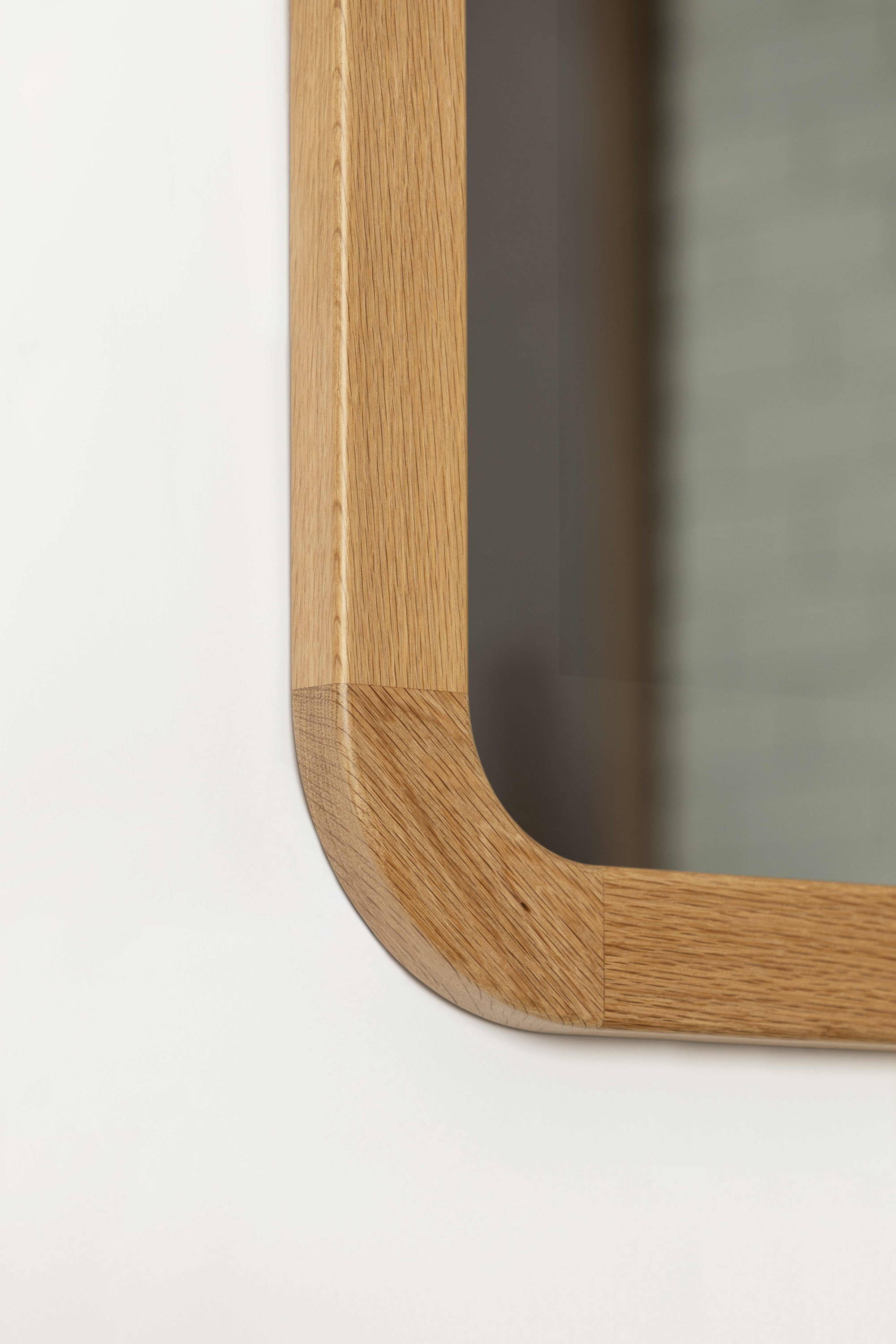 Contemporary Curve TV-Mirror by FRAMING TO A T - A detail shot of the light oak timber framed TV Mirror with contemporary curved corner.