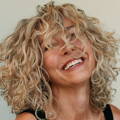 woman smiling with curly, blonde hair