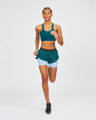 Woman wearing sustainable running set in a deep turquoise from sustainable clothing brand Janji, based in Boston in USA