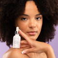 Image of a woman holding bakuchiol serum