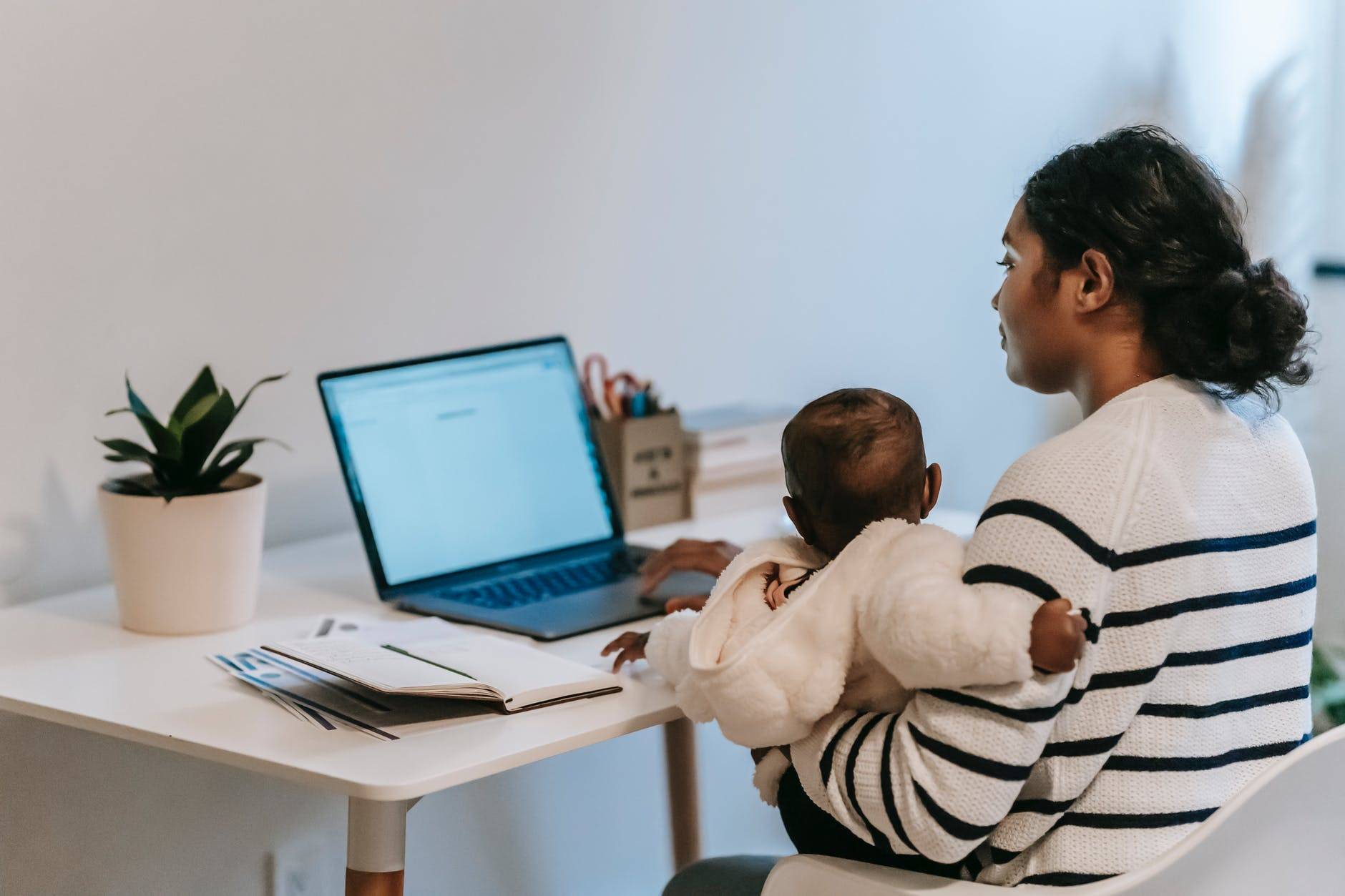 A mom working from home while holding her child