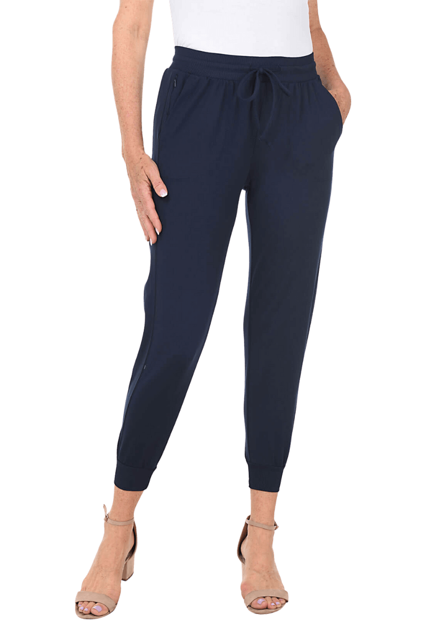 A woman wearing a navy blue jogger pant and neutral-colored strappy heels