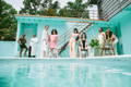 8 people model on the side of the pool deck for poolside pride: a slim aarons-inspired pride campaign