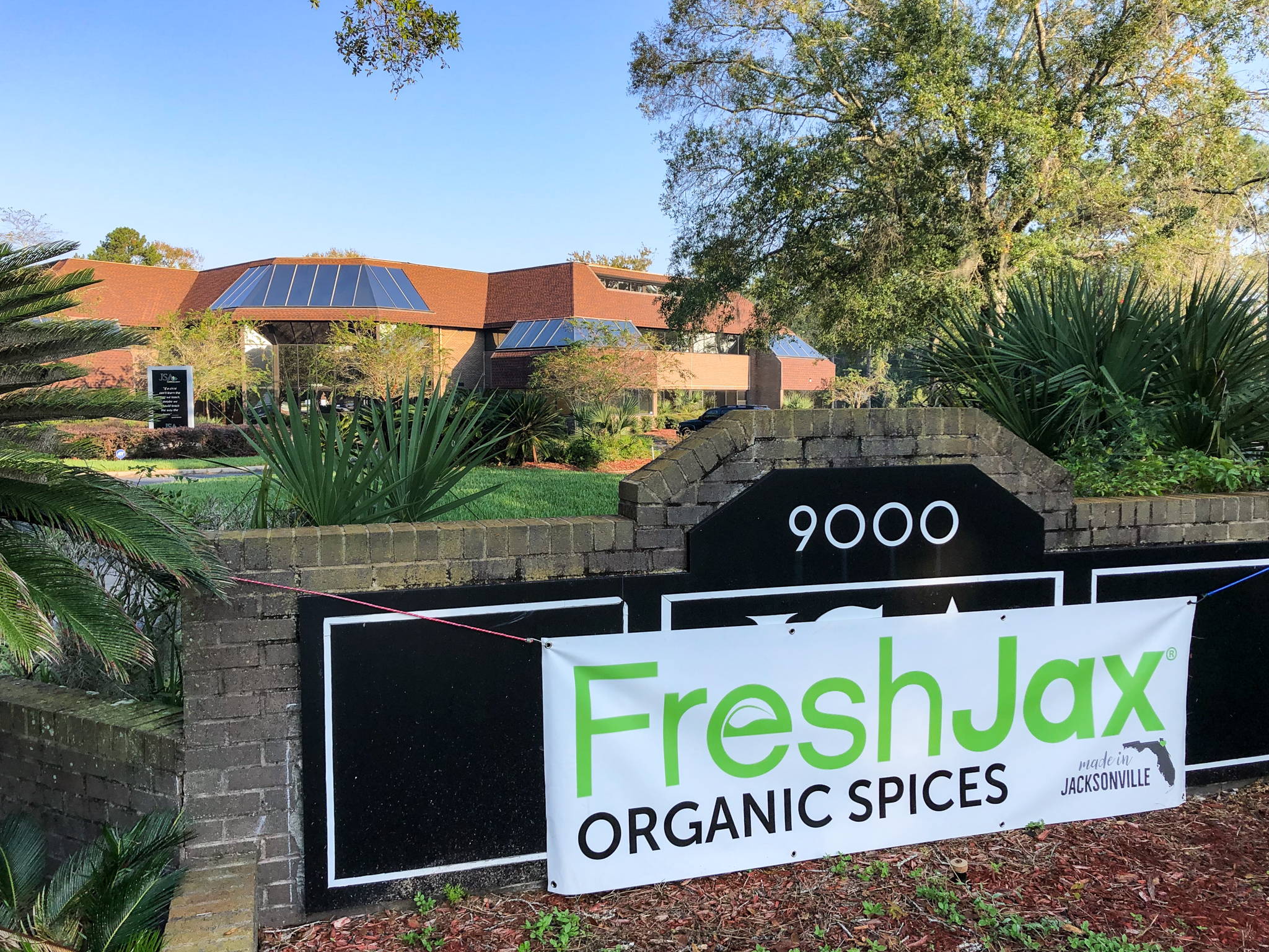 FreshJax Organic Spices sign hanging in front of new building