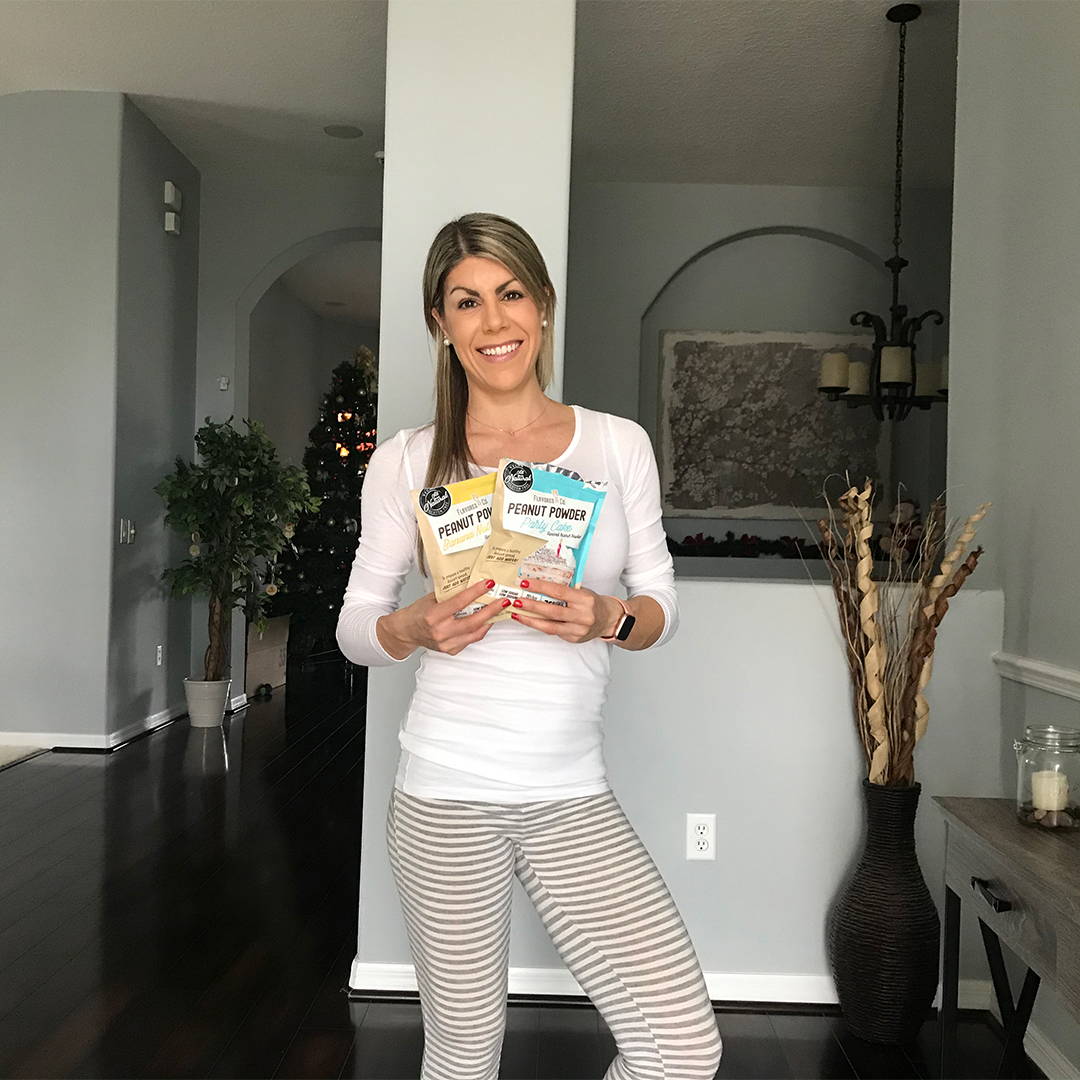 Woman adding flavored pb co powder to protein shake