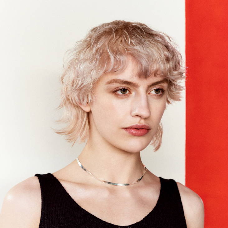 Davines model with blonde short curly hair with bangs