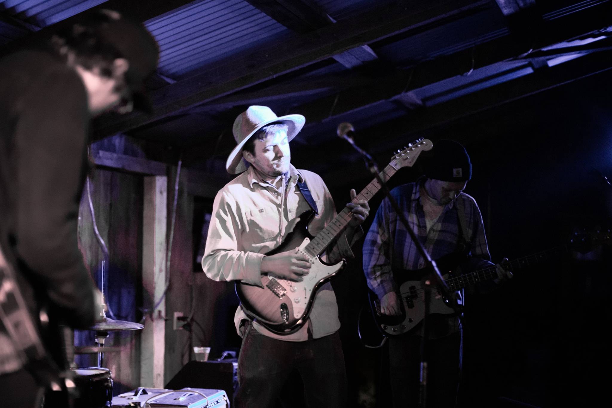 Man planning guitar with a hat on 