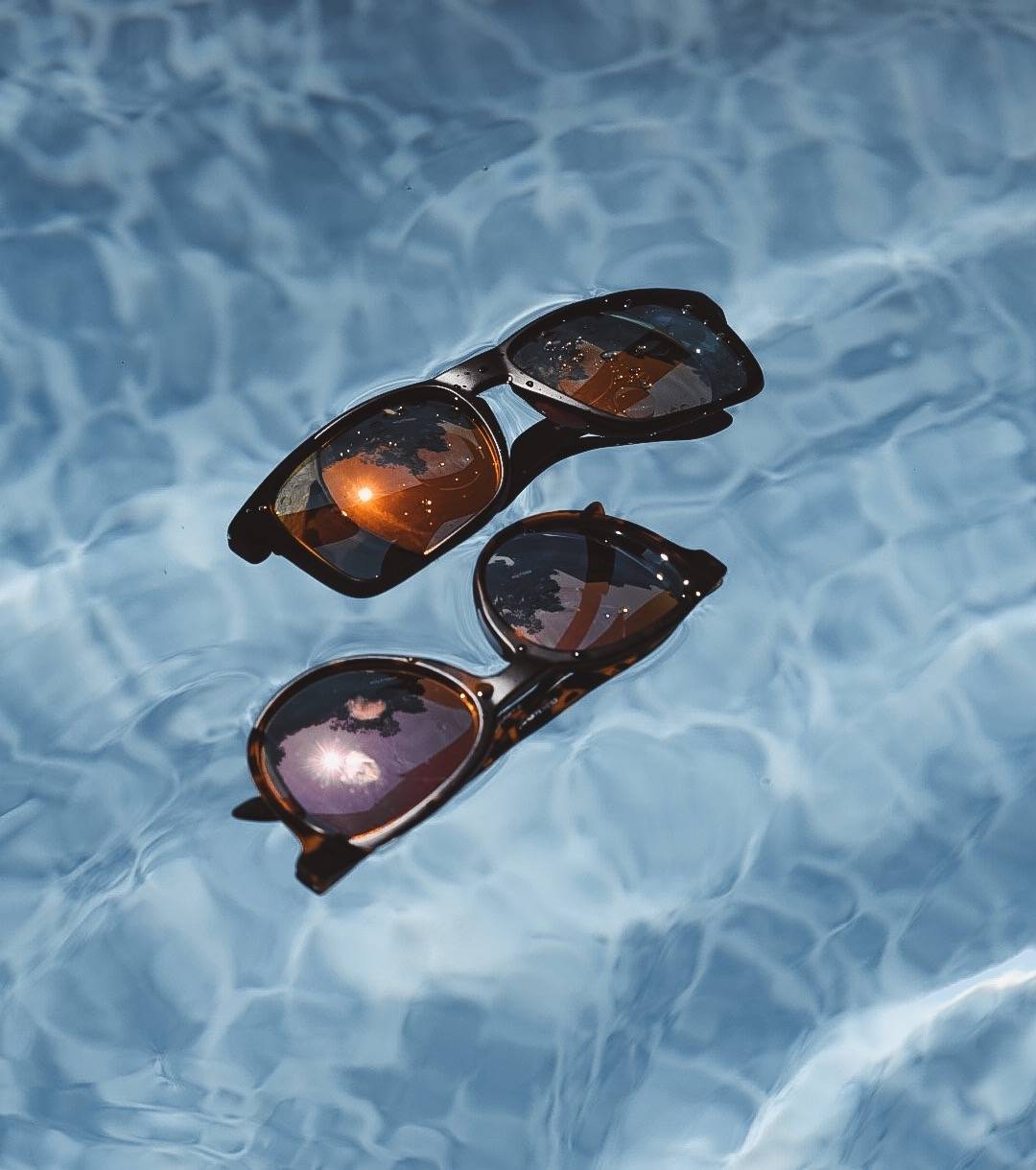 Two pairs of Rheos sunglasses float perfectly in the water.