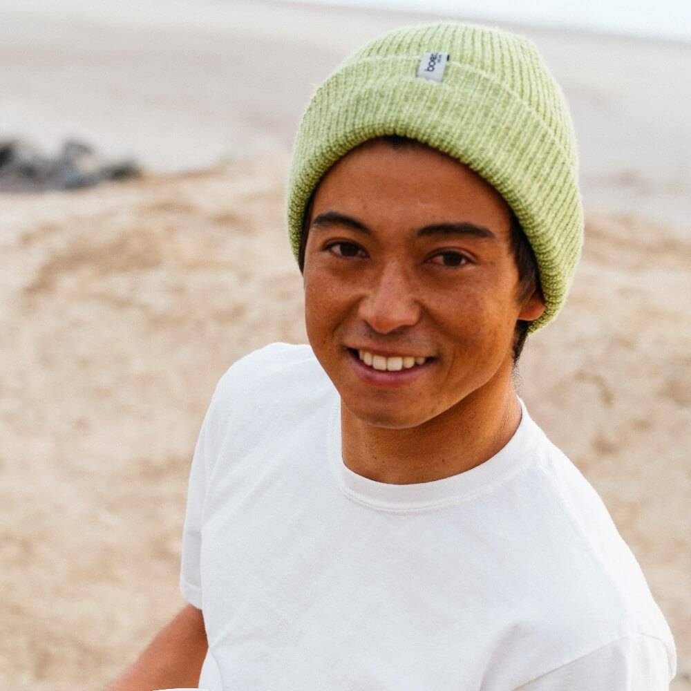 Kei wearing a green hat and white t-shirt
