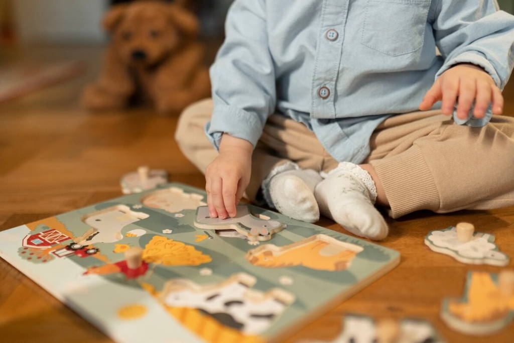 Toddler playing with Montessori farm-themed wooden puzzles.