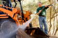 Male Pressure Washing Mud off of Heavy Equipment