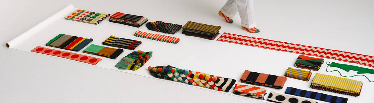 colourful Jo Gordon knitwear laid out on a roll of white paper