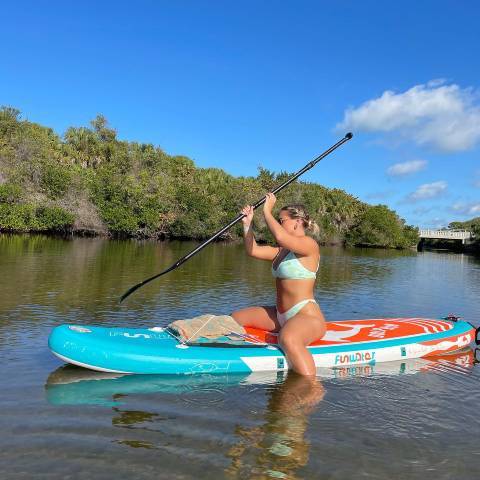 Customer stand up paddleboarding with her best inflatable paddle boards under $300