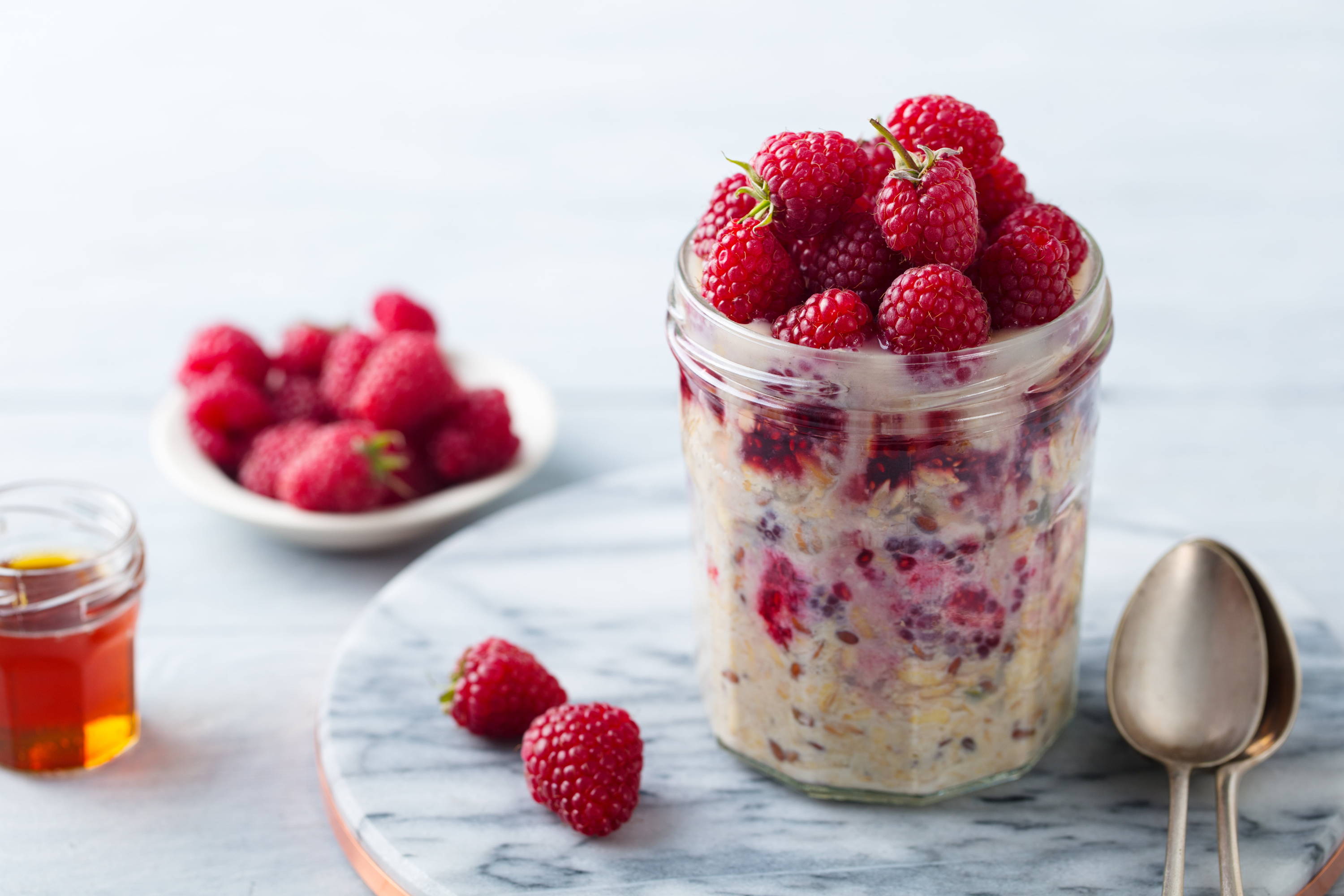 Vegan overnight oats in a mason jar with vegan collagen powder, milk, chia seeds and raspberries