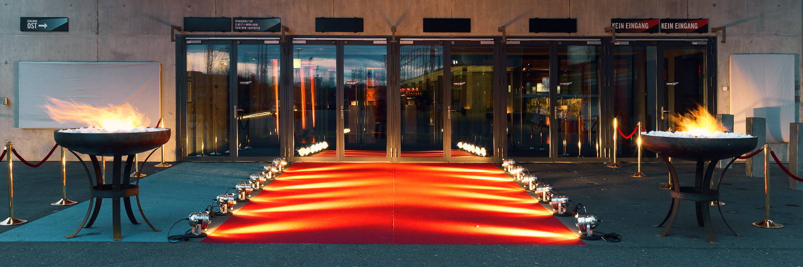 Feuerschale mieten für Event Eingangsbereich mit rotem Event Teppich und roten Kordeln