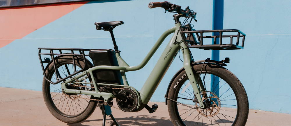 A green Momentum PakYak E+ electric cargo bike