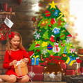 A little girl in a red dress opening a gift next to a Montessori felt Christmas Tree.