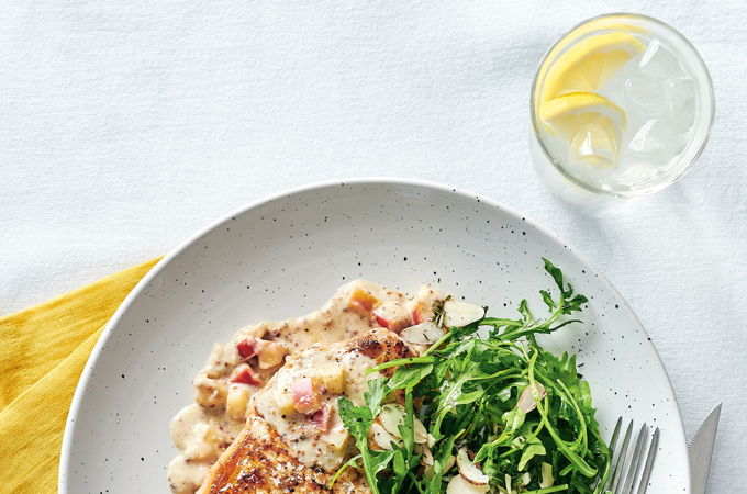 Côtelettes de porc, sauce pomme et moutarde et salade de roquette