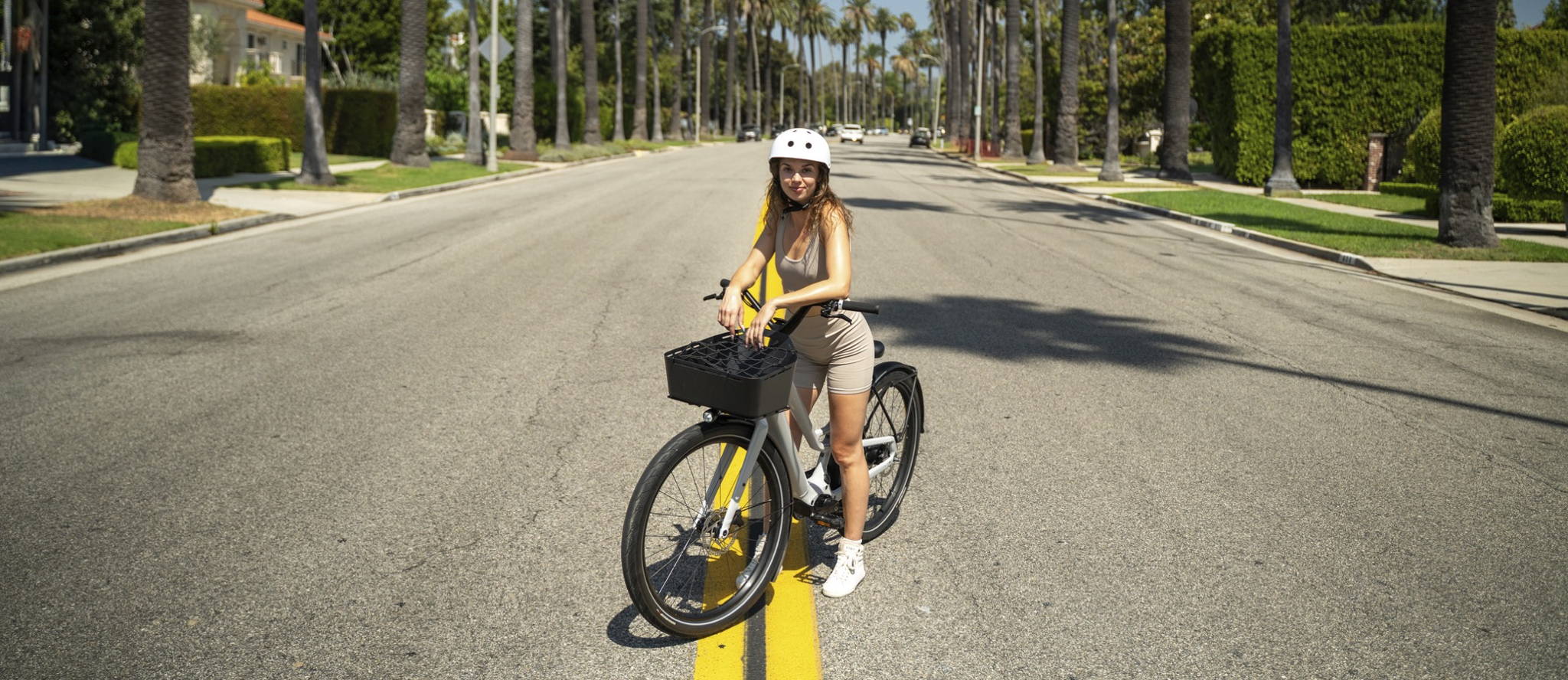 A woman standing over an electric bike in beverly hills, california