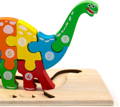 Close-up of a colorful dinosaur puzzle placed on a wooden stand. 