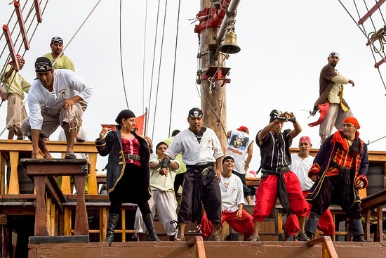 A large group of pirates dancing on the deck of a boat.