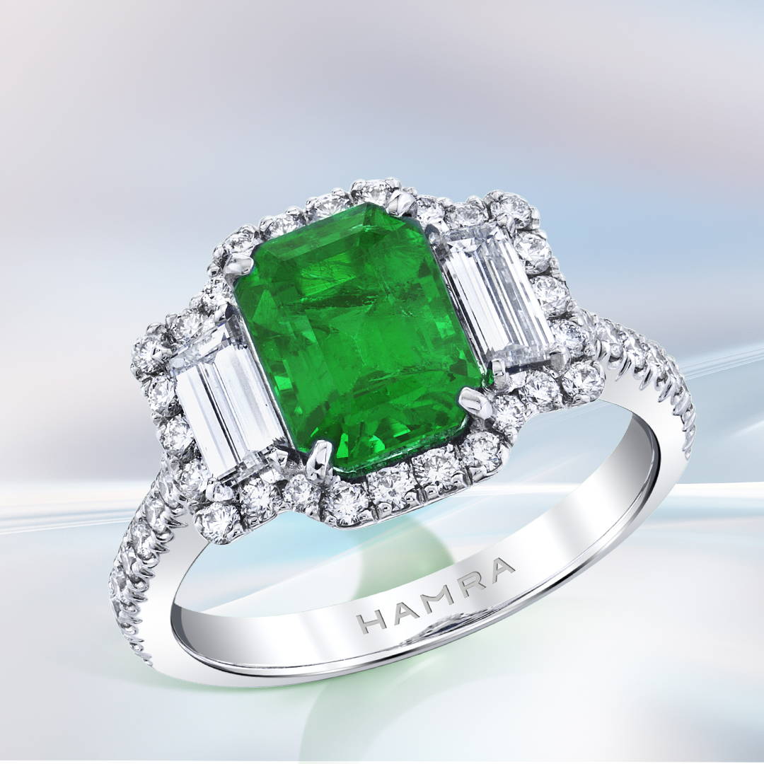 Emerald and diamond engagement ring in white gold.