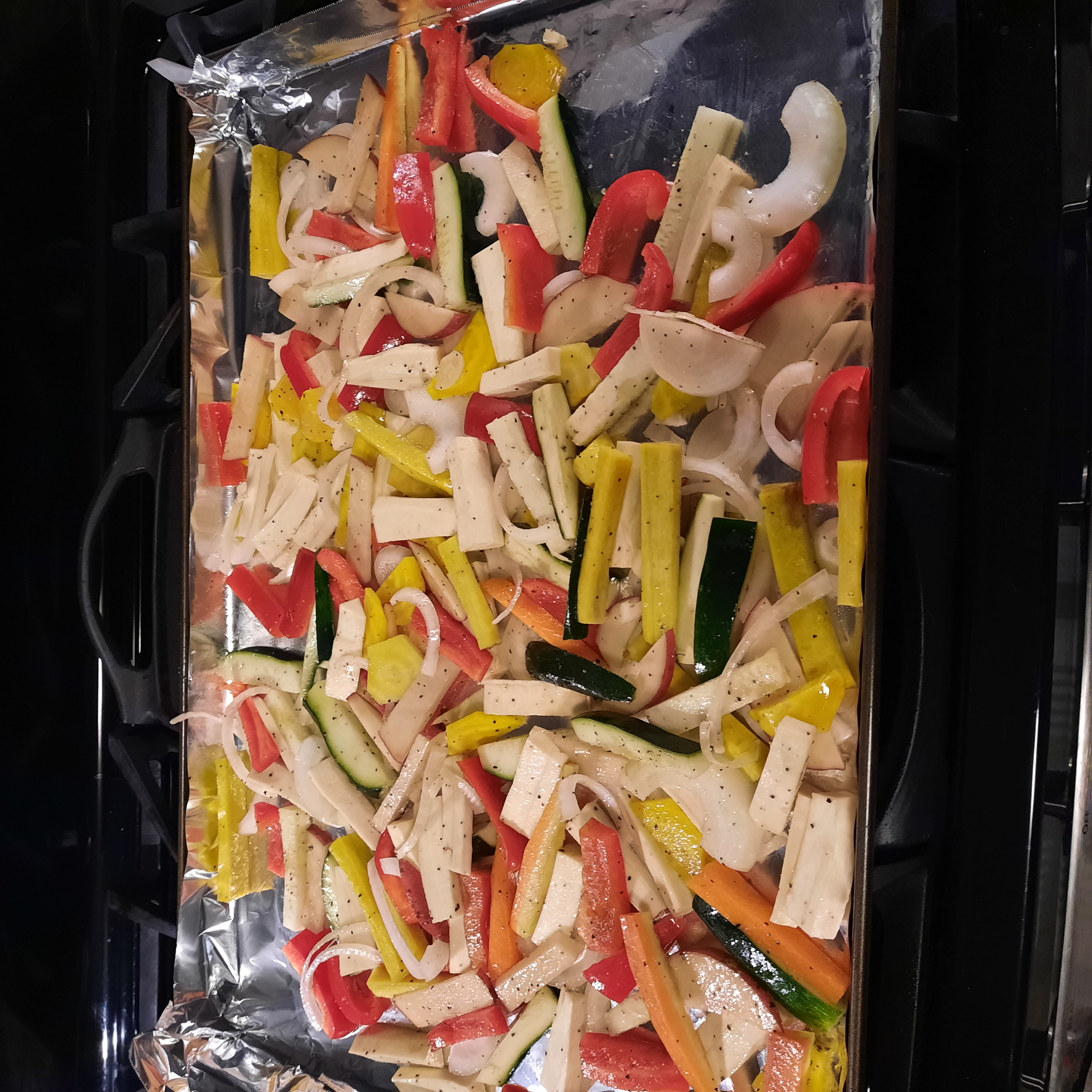 Chopped vegetables on a baking sheet lined with foil