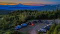 Camper Vans gathered at a campfire at sunset