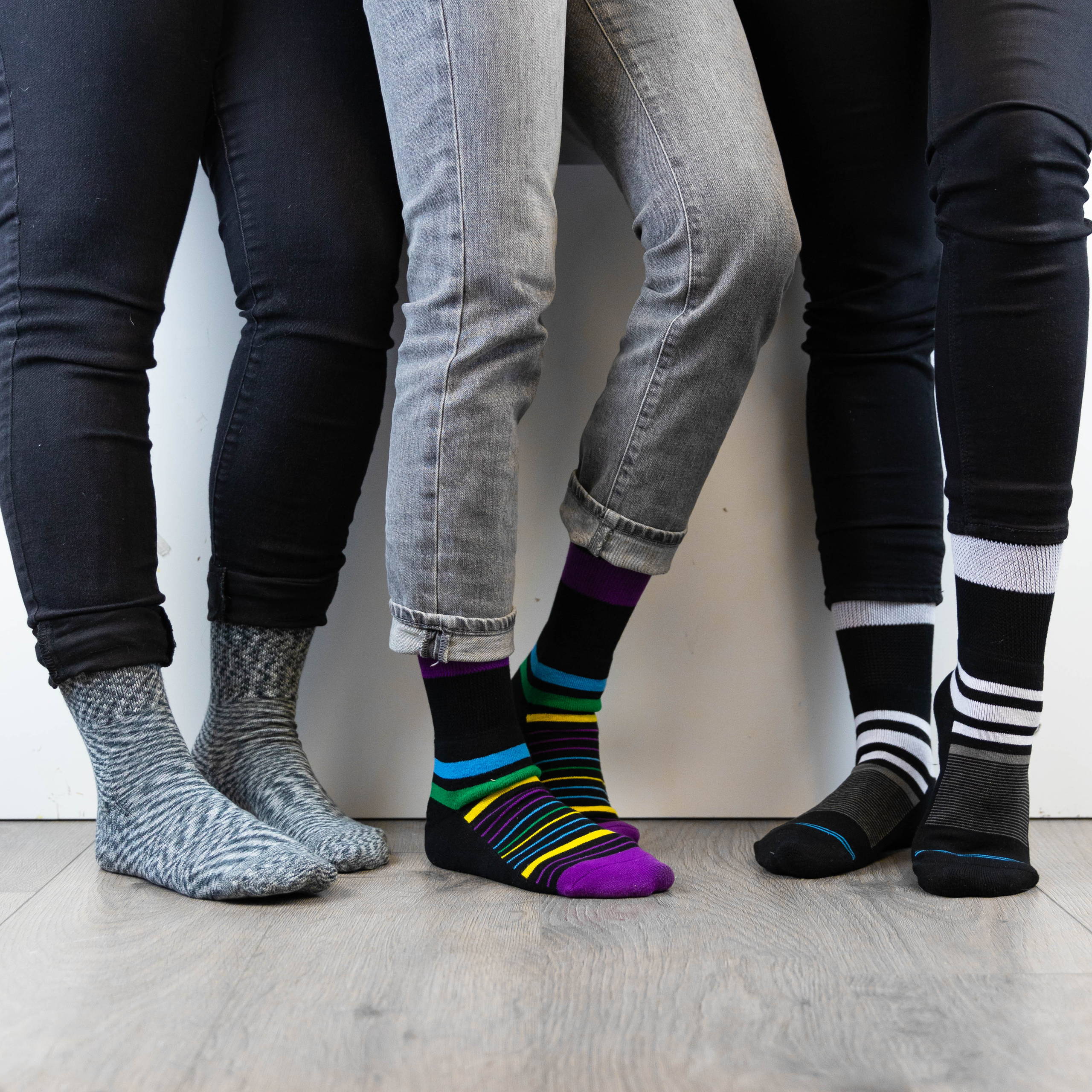 Three people standing next to eachother, all wearing Dr. Segal's diabetic socks.