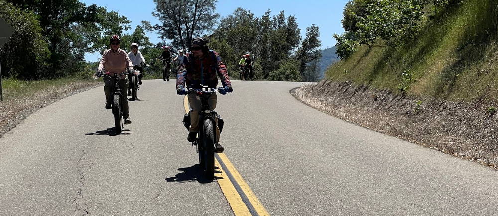 eight electric bike riders on a paved road in mariposa, california, while on a tour with yosemite e-biking (yosemiteebiking.com)