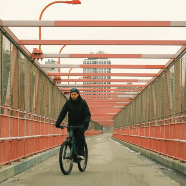 a man riding across a bridge in New York City