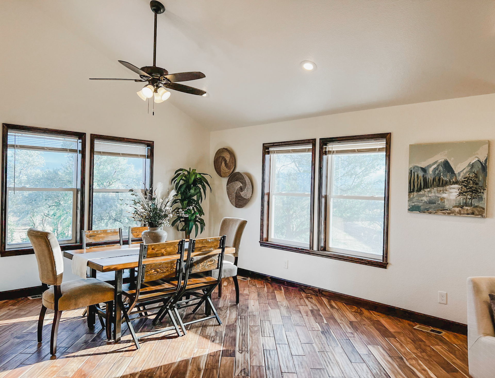 wood floored dining room featuring natural light, a ceiling fan, and vaulted ceiling