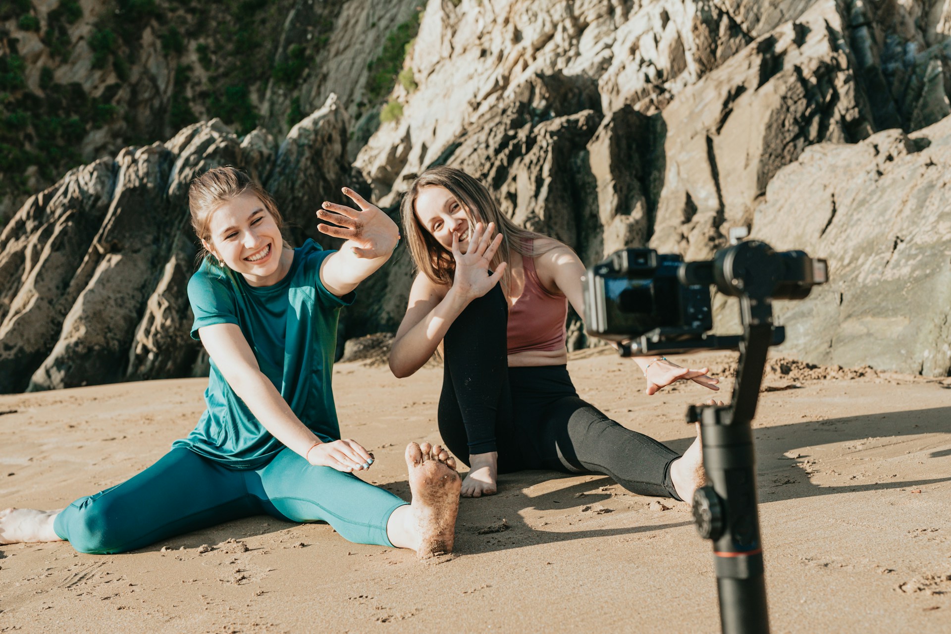 Two girls recording a fun video with a GoPro on a beach.