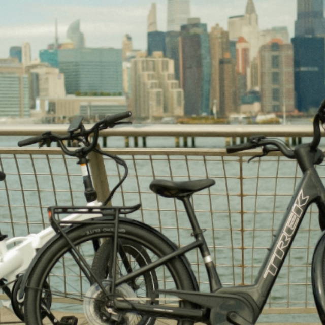 a trek and an lectric electric city bike next to the water in new york city