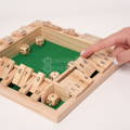 Hand interacting with a wooden Montessori dice and numbers game.