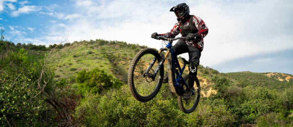 An e-MTB rider on a trail jumping