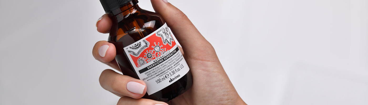 Davines' ENERGIZING Superactive being held in a hand